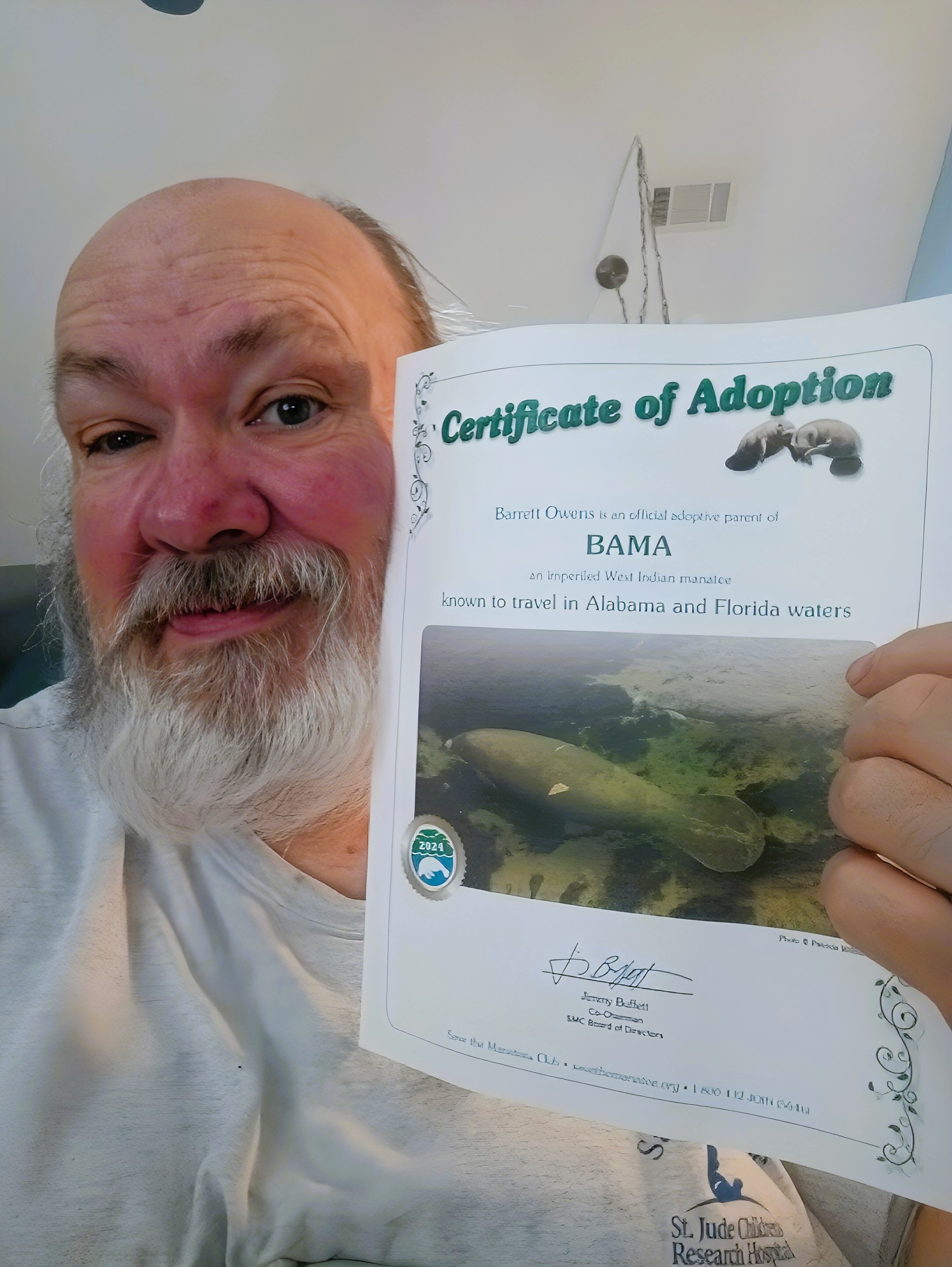 Barrett holding Bama's Certificate of Adoption from Save the Manatee Club